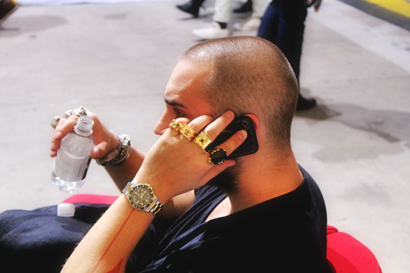 A man wearing gold rings in every finger